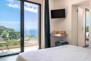 a bedroom with a large window with a view of the ocean at Moddissi Charme camere in Trappola