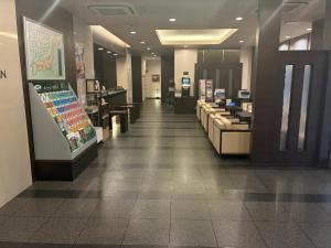 a lobby of a store with couches and a pharmacy at Hotel Route-Inn Ashikaga Ekimae in Ashikaga