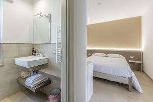a bedroom with a bed and a sink and a mirror at Nova Suite in Calatafimi +206 photos
