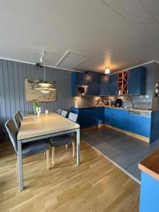 a kitchen with blue cabinets and a table and chairs at Central Apartment with Sauna & Balcony in Åre +5 photos