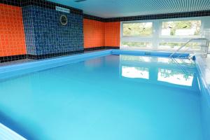 an empty swimming pool with an orange and blue wall at ROD32 Ferienwohnung Schneider in Niendorf