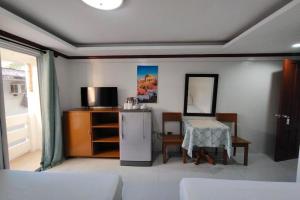 a living room with a table and a refrigerator at Shenna's Beach Resort Boracay in Boracay