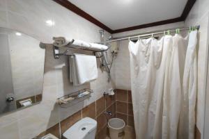 a bathroom with a white shower curtain and a toilet at Shenna's Beach Resort Boracay in Boracay +43 photos