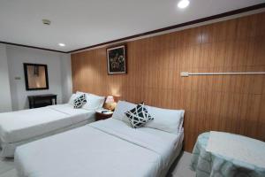 two beds in a hotel room with wooden walls at Shenna's Beach Resort Boracay in Boracay
