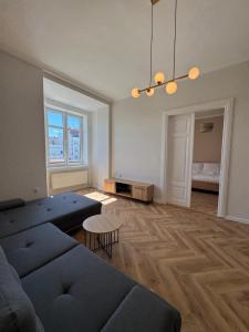 a living room with a blue couch and a table at Apartamenty Rynek 7 in Cieszyn