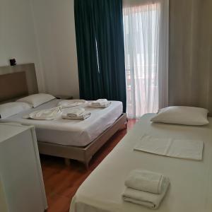 a room with two beds and a window at Koli Apartments in Ksamil