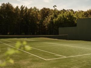 a tennis court with a net and some trees at Mas de Torrent Hotel & Spa, Relais & Châteaux in Torrent +34 photos