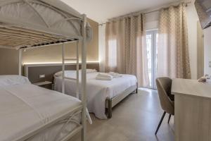 a bedroom with two bunk beds and a desk at Nova Suite in Calatafimi