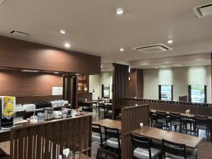 a dining room with wooden tables and chairs at Hotel Route-Inn Ashikaga Ekimae in Ashikaga