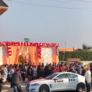 a crowd of people standing around a white car at Vani Hotel Golden Petals in Una +22 photos