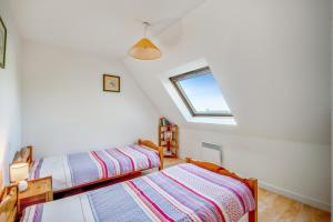 a attic bedroom with two beds and a window at Appartement confortable avec terrasse à Arzon - 60 m² in Arzon