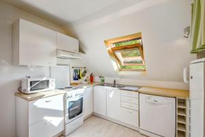 a small kitchen with white appliances and a window at Appartement confortable avec terrasse à Arzon - 60 m² in Arzon +12 photos