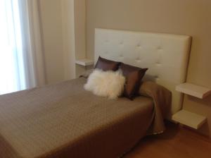 a bed with a white furry pillow on it at Spacious Apartment in Terrassa with Shared Pool, 85 m² in Terrassa