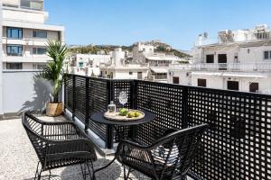 a patio with two chairs and a table on a balcony at PAME Wild in Athens