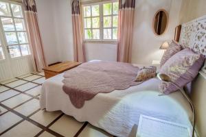a bedroom with a large bed and two windows at Villa avec piscine à Saint-Gilles les Bains, 260 m², 9 pers. in Saint-Gilles-les-Bains