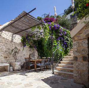 a patio with a table and chairs and flowers at Elegant villa in Podgora with private pool and sea view in Podgora