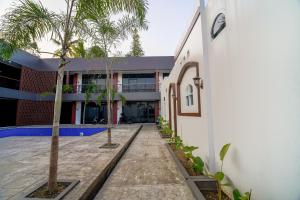 a courtyard of a building with palm trees in front of it at Timeless Sevilla Luxe in Ngemplak