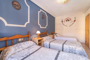 two beds in a room with blue walls at Spacious apartment with sea view in La Mata - 75 m² - Pool in La Mata