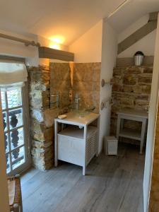 a bathroom with a sink and a stone wall at Villa spacieuse à Haut-de-Bosdarros avec piscine privée in Haut-de-Bosdarros