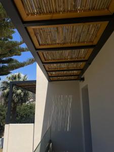 a wooden roof on a building with a porch at Nikos Apartments & Studios in Plakias