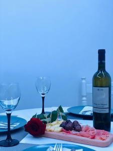 a table with a bottle of wine and a plate of food at Apartment in Shtip in Štip