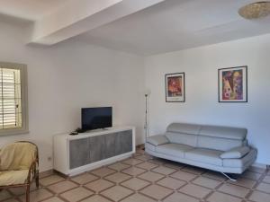 a living room with a couch and a tv at Beautiful Villa in Caccamo + Pool in Caccamo