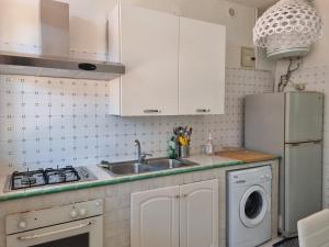 a kitchen with white cabinets and a sink and a dishwasher at Beautiful Villa in Caccamo + Pool in Caccamo