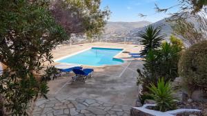 an image of a swimming pool with chairs and trees at Charming House in Paros, 90 m² with Shared Pool in Parikia