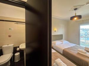 a bedroom with a bed and a sink and a toilet at Celeste Blu Suites & Rooms in Paralia Katerinis