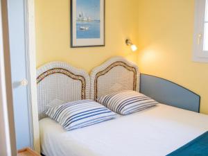 a bed with two striped pillows in a room at Appartement convivial à Gassin 37 m² avec vue sur la mer in Gassin +6 photos