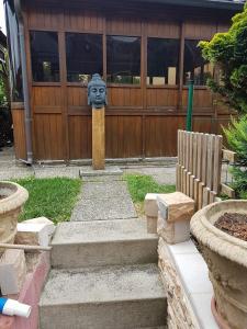 a gate with a statue of a face in a yard at Comfortable studio in Bevaix with mountain view - 30 m² + Spa in Bevaix