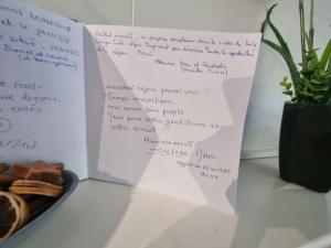 a book with writing on it next to a plate of food at Comfortable studio in Bevaix with mountain view - 30 m² + Spa in Bevaix +24 photos