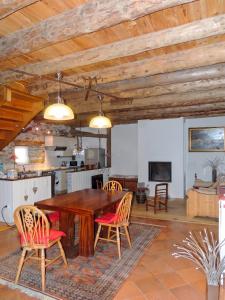 a kitchen and dining room with a wooden table and chairs at Maison chaleureuse à Mont >Vue montagne & cheminée in Mont