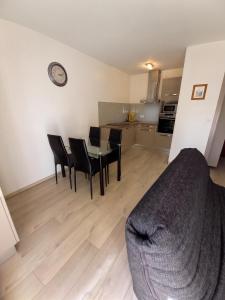 a living room with a couch and a table and chairs at Appartement charmant à Chambéry de 35 m² + balcon privatif in Chambéry
