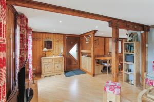 a living room with wood paneling and a kitchen at Chalet charmant à Stosswihr avec vue sur montagne + balcon in Stosswihr