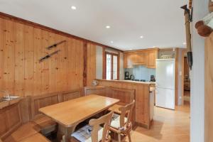 a kitchen with a wooden table and a refrigerator at Chalet charmant à Stosswihr avec vue sur montagne + balcon in Stosswihr
