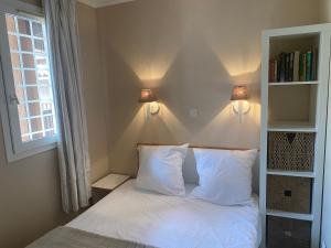 a bedroom with a bed with two pillows and a window at Appartement familial avec vue sur la mer à Agay - 40 m² + piscine in Agay - Saint Raphael +16 photos