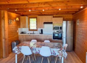 a kitchen with a table and chairs and a refrigerator at Chalet charmant à Saint-Gènes-Champespe avec parking privé in Saint-Genès-Champespe +23 photos