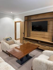 a living room with a table and a television at Al-Amin in Termiz
