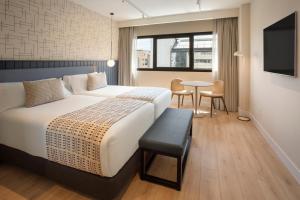 a hotel room with a bed and a table at Catalonia Málaga in Málaga