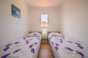 two beds in a small room with a window at Bright Apartment in Vrsi with Terrace and Garden, 65 m² in Vrsi +7 photos