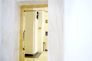 a hallway with a mirror and a white wall at TR Residency in Pondicherry