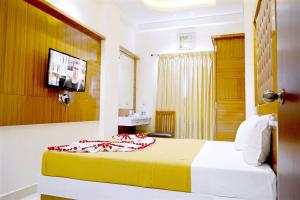 a hotel room with a bed and a television at TR Residency in Pondicherry