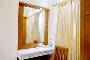 a bathroom with a sink and a mirror at TR Residency in Pondicherry