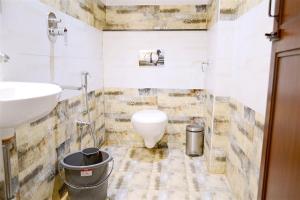 a bathroom with a toilet and a sink at TR Residency in Pondicherry