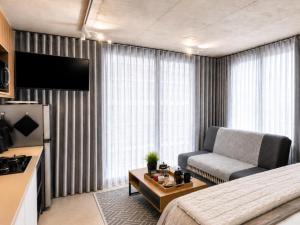 a hotel room with a bed and a couch at Burleigh Ballito in Ballito