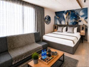 a hotel room with a bed and a couch at Burleigh Ballito in Ballito +3 photos