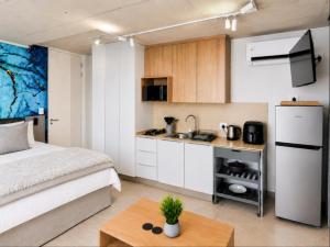 a bedroom with a bed and a small kitchen at Burleigh Ballito in Ballito
