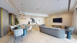 a living room with a couch and a table and chairs at Vacationer Holiday Homes I Luxurious 3 Bedroom I Iconic FIVE Palm in Dubai