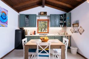 a kitchen with green cabinets and a wooden table and chairs at Spacious House with Private Pool in Stari Grad in Stari Grad
